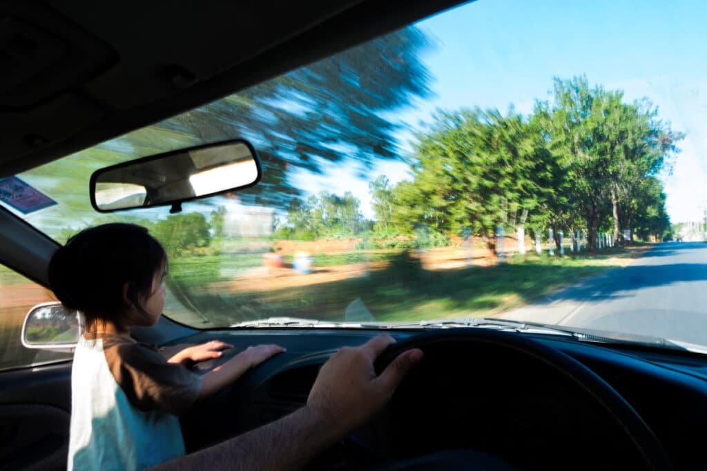 Small child looking through front car window