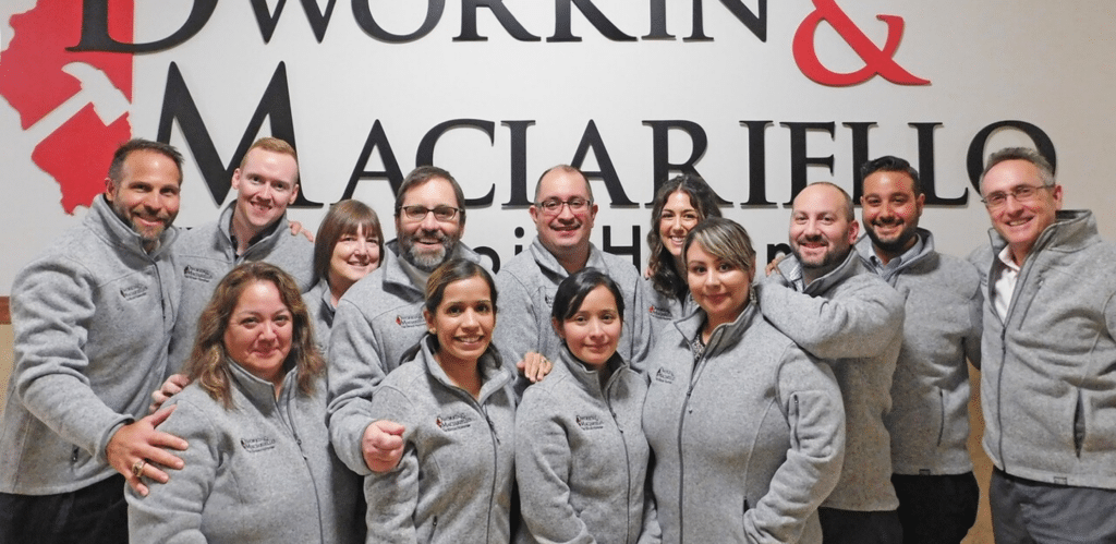 The Illinois Hammer team posing in hallway of their office in branded fleeces smiling