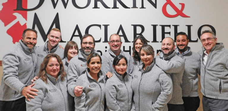 The Illinois Hammer team posing in hallway of their office in branded fleeces smiling