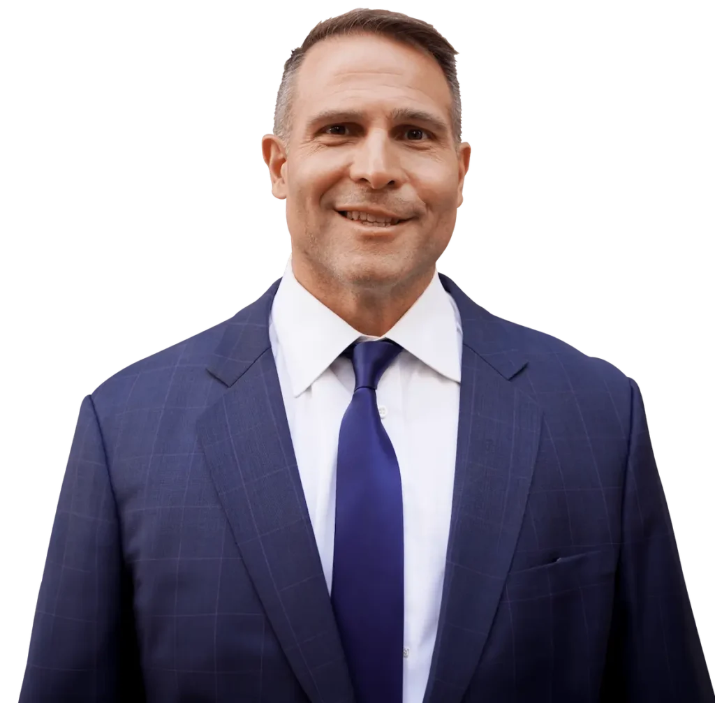 Portrait of Domenic Maciariello, a professional lawyer, in a blue suit and tie, smiling at the camera.