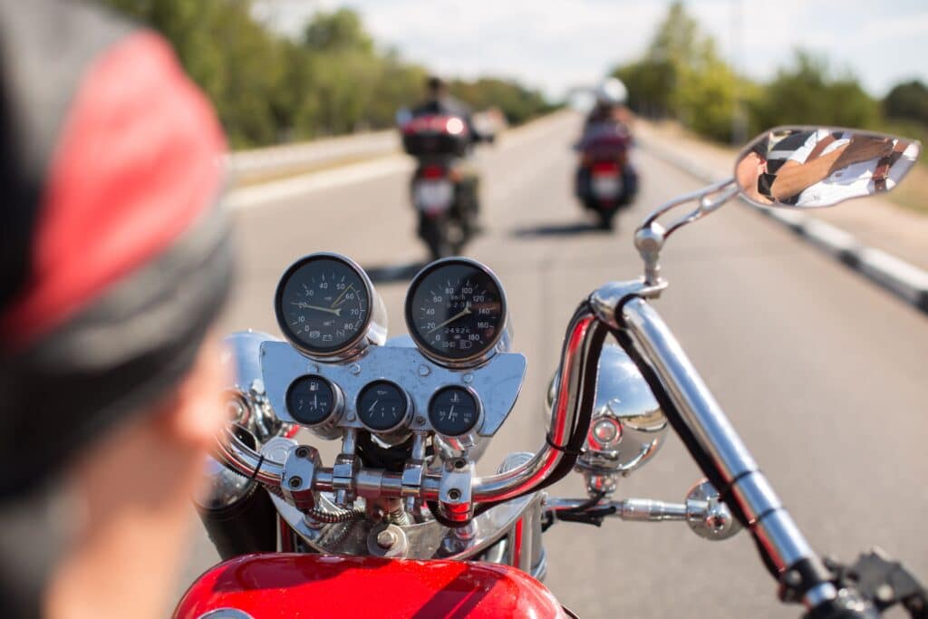 Biker riding motorcycle on road in sunny morning